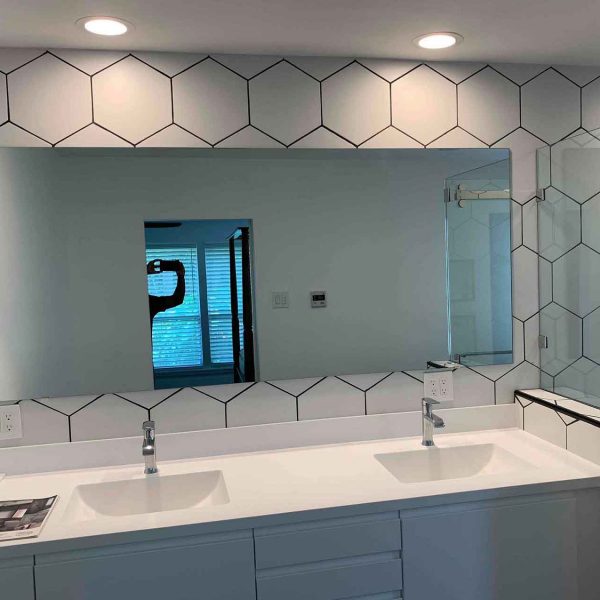 A wide mirror in the modern bathroom area