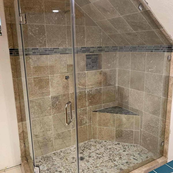 A cornered shower area with glass door