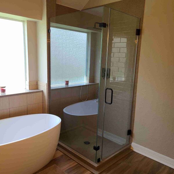 A cornered shower area with glass door