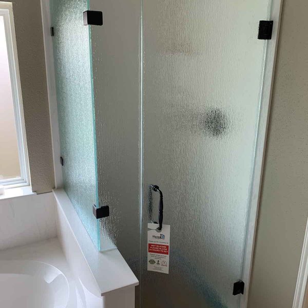 A shower door with decorative glass