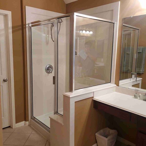 A simple cornered shower area with glass door