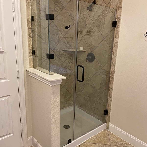 A cornered shower area with glass door