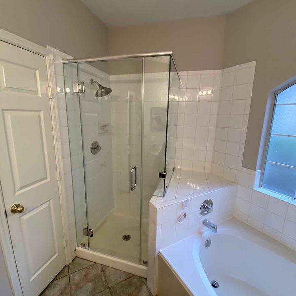 A cornered shower area with glass door