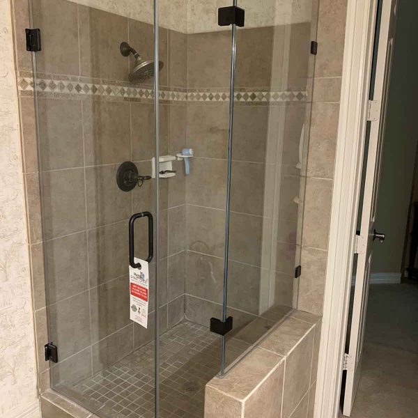 A cornered shower area with glass door