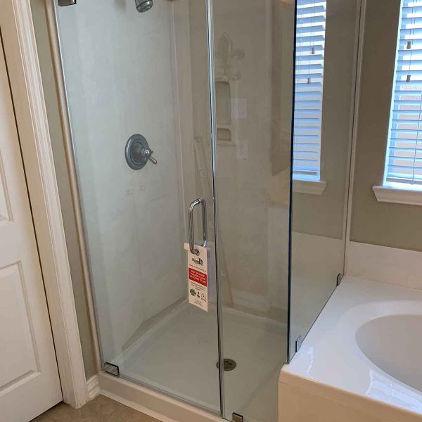 A cornered shower area with glass door