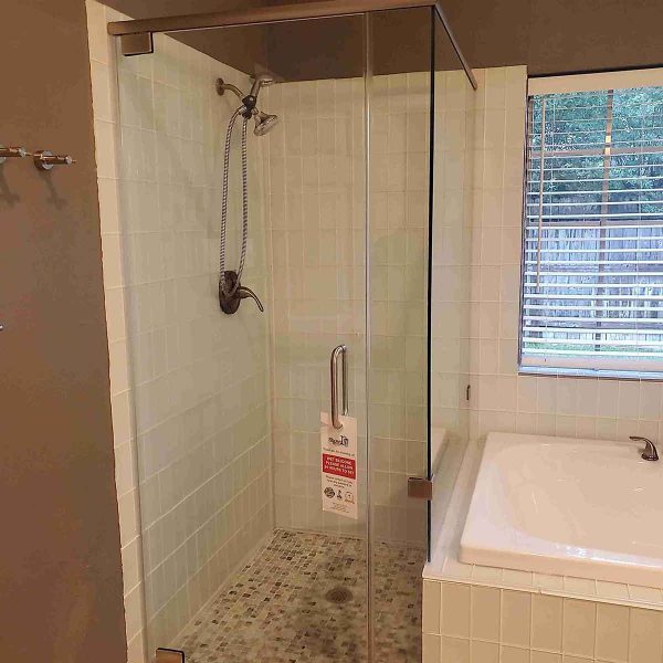 A cornered shower area with glass door