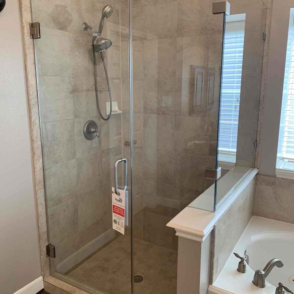 A simple cornered shower area with glass door