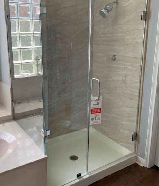 A cornered shower area with glass door